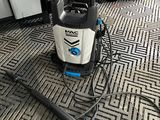 un aspirateur posé par terre, sur lequel est posée une pancarte