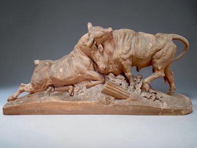 sculpture représentant un taureau et une vache en train de se battre sur un rocher