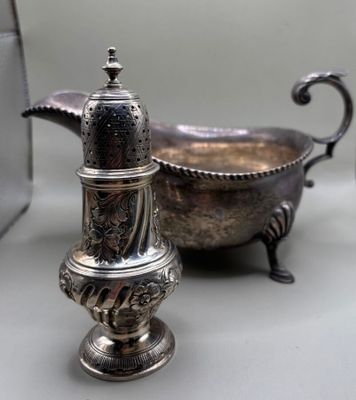 a silver salt and pepper shaker sitting next to a silver bowl