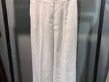 un pantalon blanc suspendu à un portant dans une pièce