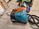 an image of a blue vacuum cleaner on the ground