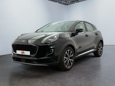 Une voiture noire est garée dans une grande pièce aux murs blancs.
