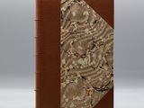 un livre marron avec un motif floral sur la couverture