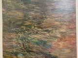 tableau accroché au mur d'une pièce où se trouvent un canapé et une table