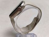 a silver apple watch sitting on a clear stand