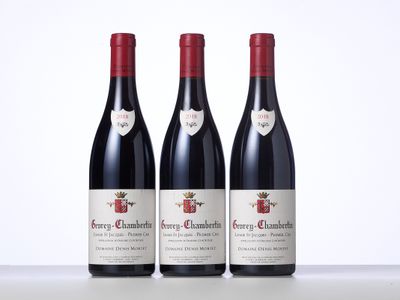trois bouteilles de vin rouge posées sur une table