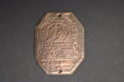 a small metal plaque with a picture of a man and a woman on it