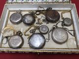 a box that has a bunch of silver pocket watches in it