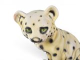 a white and black leopard figurine sitting on a white surface