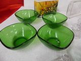 three green glass bowls sitting on top of a table next to a box
