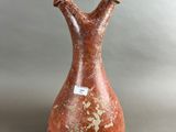 an image of a red vase with a white tag on it
