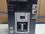 packaging of a coffee maker sitting on a table in front of a cardboard box