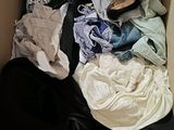 a cardboard box filled with clothes and a pair of shoes