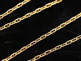 a close up of a gold chain on a black surface