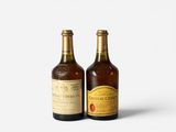two bottles of wine sitting next to each other on a white surface
