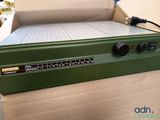 a green machine that is sitting on top of a cardboard box