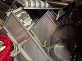 un tas d'objets divers et un ventilateur dans un garage