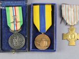 deux médailles et une croix se trouvent dans une boîte bleue
