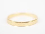 gros plan d'une bague en or sur une surface blanche