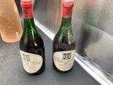 two bottles of wine sitting on a counter in front of a window