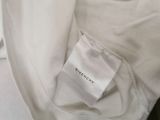 the label on a white shirt is attached to the back of a white jacket