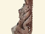 une statue représentant un dragon assis sur un socle en bois