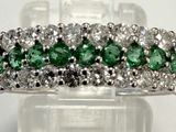 un gros plan d'une bague en diamant verte et blanche