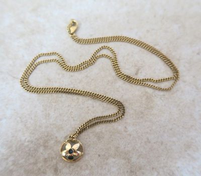 Gros plan sur un collier en or orné d'une croix