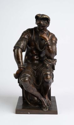 bronze statue of a man sitting on a stool with a dog