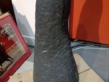 a large black object sitting on top of a cardboard box
