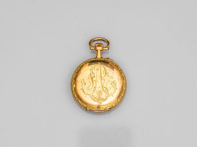 a close up of a gold pocket watch on a white surface