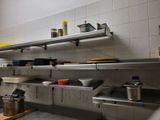many pots and pans on the shelves in the kitchen
