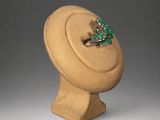 a close up of a ring on a mannequin with a green stone
