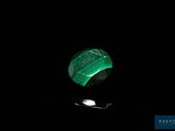 une photo d'une pierre verte avec une cuillère dans l'obscurité
