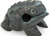 une petite grenouille en bronze posée sur une surface blanche