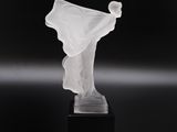 sculpture représentant une femme vêtue d'une robe blanche fluide, posée sur un socle noir