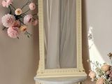 un miroir et un vase de fleurs dans un coin de la pièce