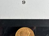 a close up of a gold coin in a box on a table