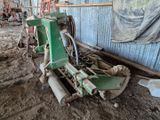 une machine verte qui est à l'arrêt dans la boue