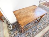 une table en bois posée sur un tapis dans une pièce