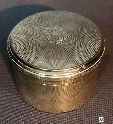 a gold box with a monogram on the lid