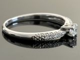 a close up of a diamond ring on a reflective surface