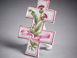 un gros plan d'une croix ornée d'une fleur