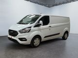 La camionnette blanche est garée dans une grande pièce au sol gris.