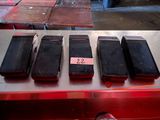 several cell phones are lined up on a table in a warehouse
