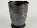 a silver cup with a design on it