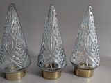three clear glass christmas trees with gold bases on a white background