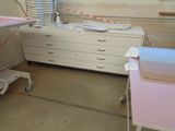 a room with a bed, a dresser, and a window in it