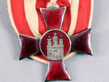an image of a red and white medal with a red cross on it