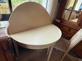 une table blanche avec une chaise et un miroir dans un coin
